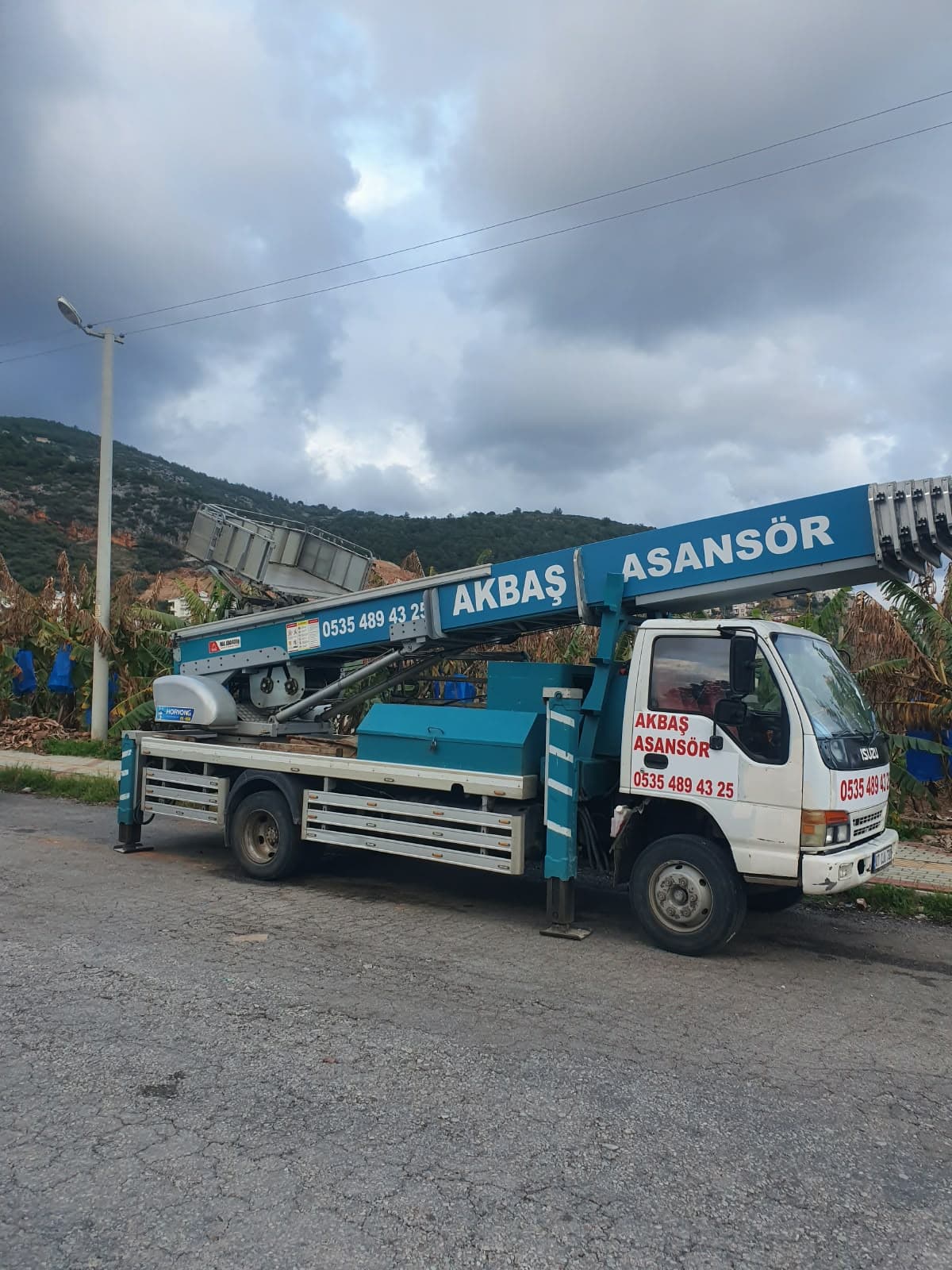 Üzerinde katlanmış dış cephe asansörü bulunan Akbaş Asansör kamyonu